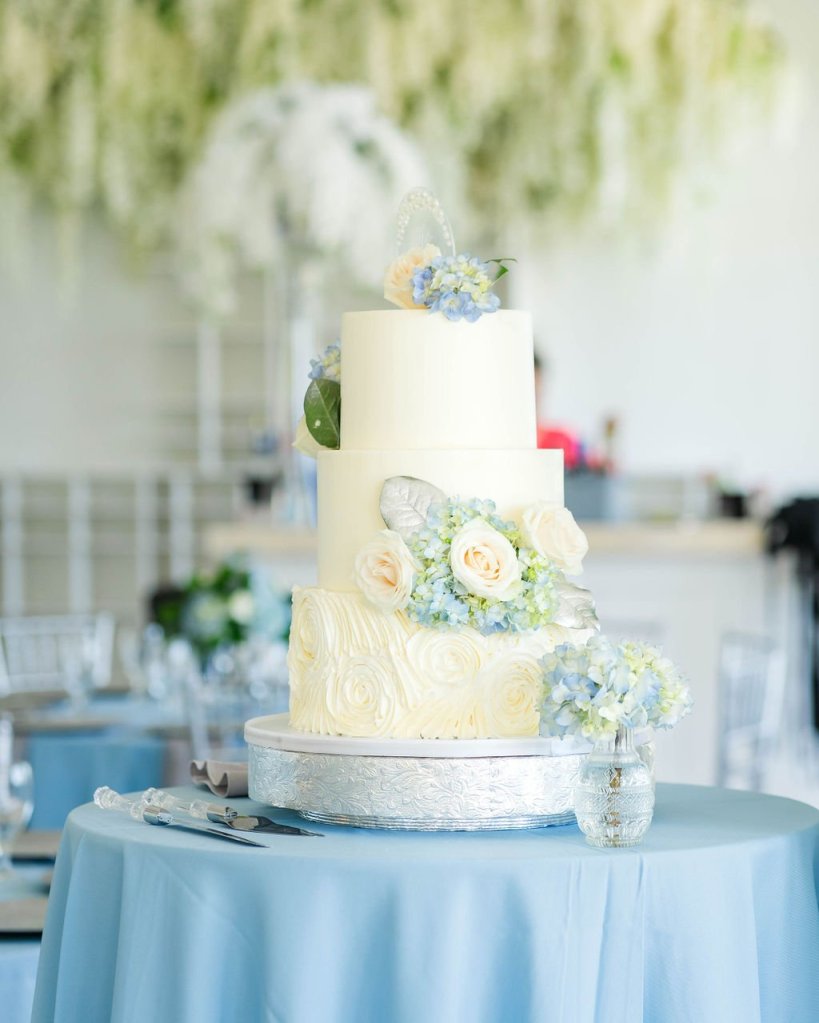 Palm Beach wedding venue reception with a luxury wedding cake adorned with luxury wedding flowers