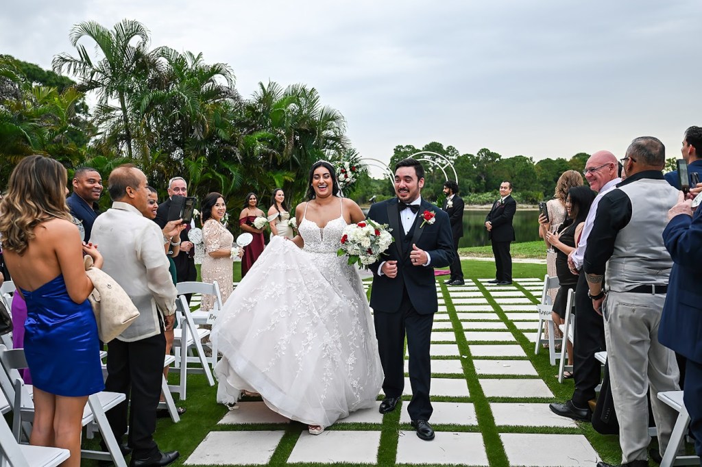 Spring Wedding Planning In Palm Beach Florida, outdoor wedding ceremony with white folding chairs, waterfront views and luxury flowers